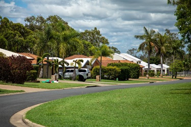 A row of neat brick houses on a quiet, grassy street
