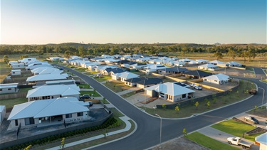 An aerial shot shows a new residential development, with streets of houses recently completed
