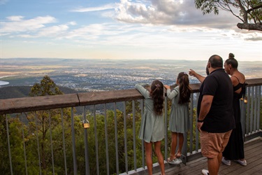 A family looks out over Rockhampton from the Mount Archer Nurim Circuit elevated boardwalk