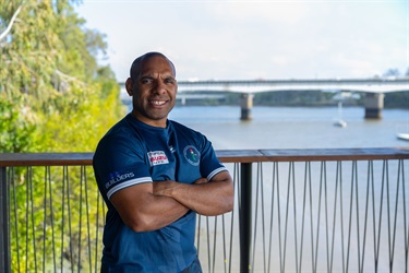 Portrait of a man with his arms crossed in front of the Fitzroy River Bridge