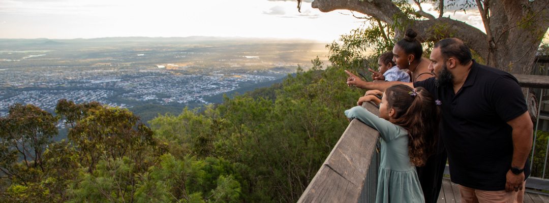 A family looks out over Rockhampton from the Mount Archer Nurim Circuit elevated boardwalk