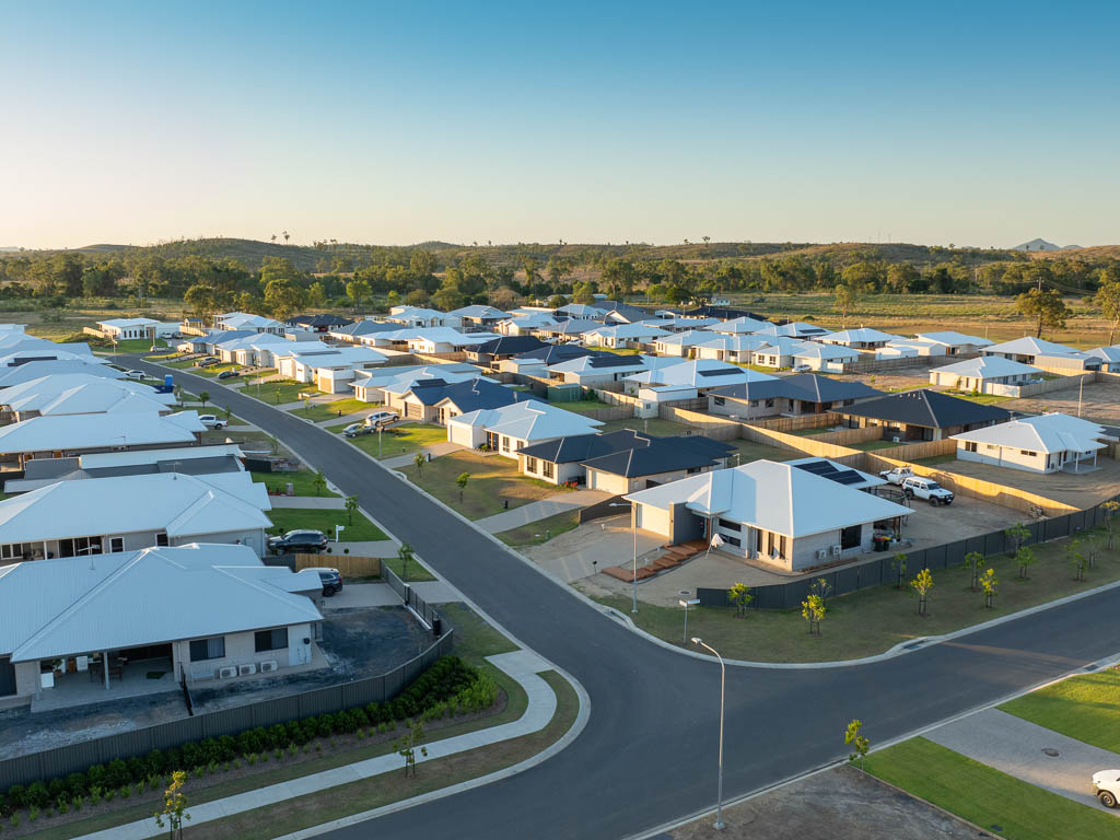An aerial shot shows a new residential development, with streets of houses recently completed